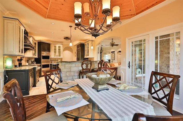 dining space with wood ceiling, ceiling fan with notable chandelier, and ornamental molding