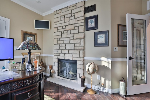 room details featuring a stone fireplace, hardwood / wood-style flooring, and ornamental molding