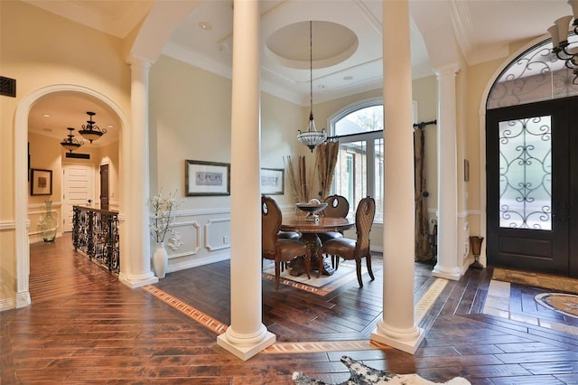 foyer with dark hardwood / wood-style flooring, ornamental molding, and a notable chandelier