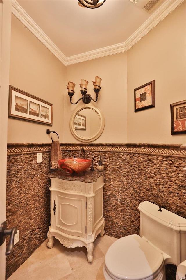 bathroom featuring tile patterned floors, toilet, vanity, tile walls, and ornamental molding