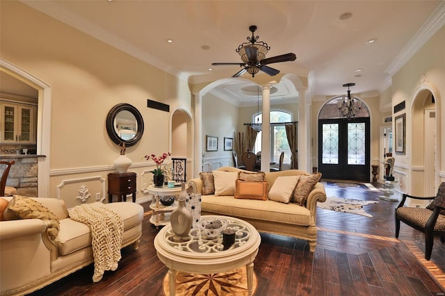 living room with ornate columns, ceiling fan, french doors, dark wood-type flooring, and ornamental molding