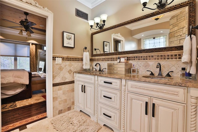 bathroom with vanity, plenty of natural light, crown molding, and tile walls