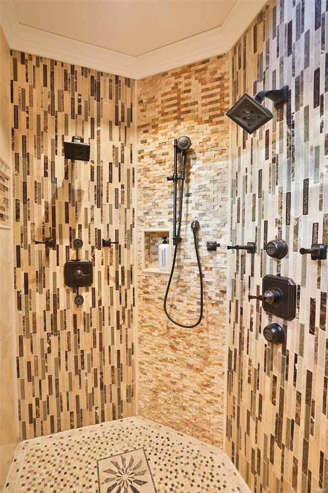 bathroom featuring ornamental molding and tiled shower