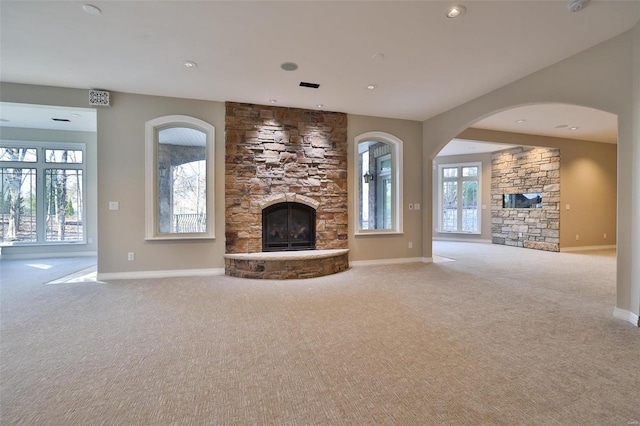 unfurnished living room featuring carpet and a stone fireplace