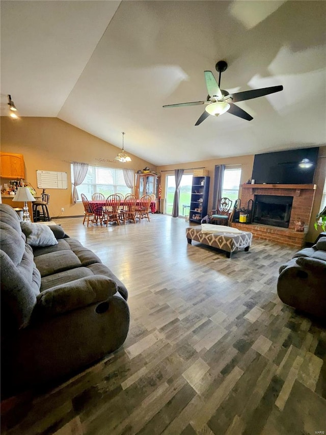 living room featuring a fireplace, hardwood / wood-style floors, a healthy amount of sunlight, and lofted ceiling