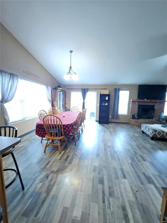 dining space featuring hardwood / wood-style flooring and vaulted ceiling