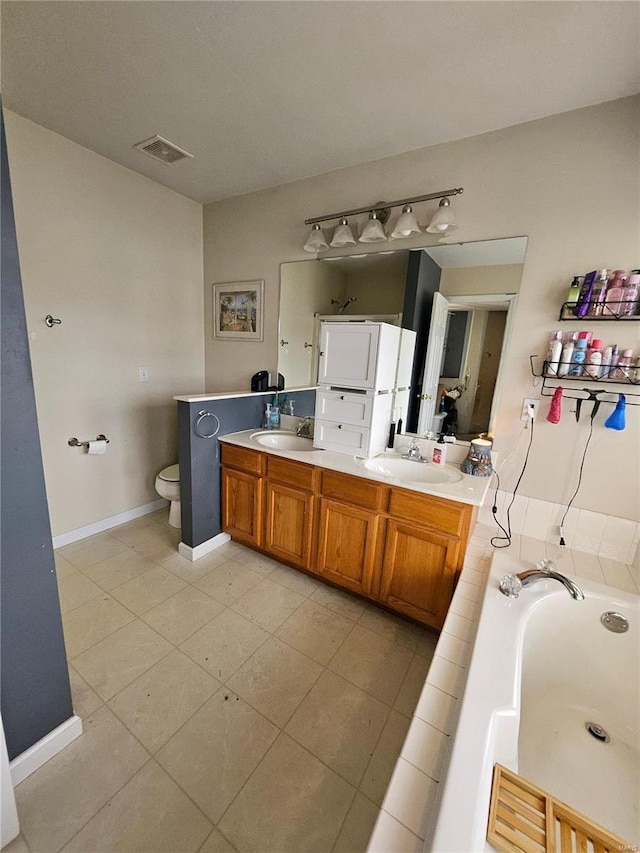 bathroom with tile patterned floors, vanity, toilet, and a bathing tub