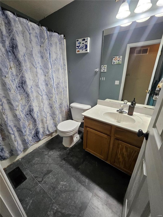 bathroom featuring vanity, toilet, and walk in shower