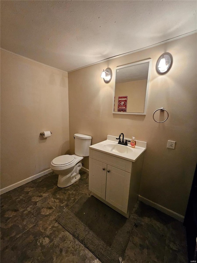 bathroom with vanity, toilet, and a textured ceiling