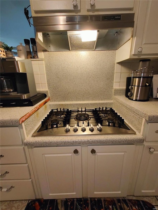 kitchen with white cabinetry, extractor fan, stainless steel gas cooktop, and decorative backsplash