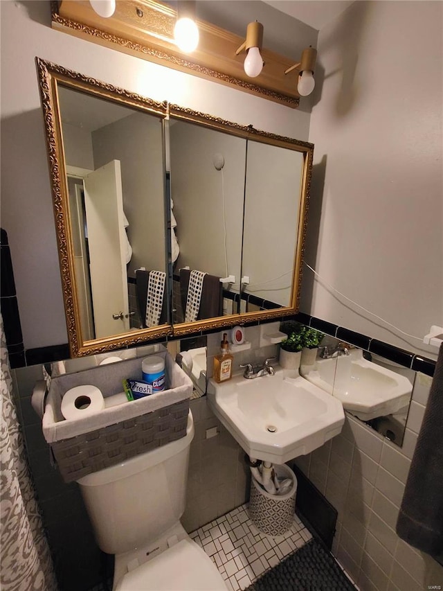 bathroom with toilet, tile walls, and tile patterned flooring