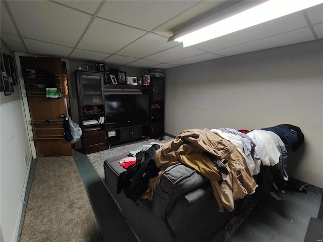 living room featuring carpet floors and a drop ceiling