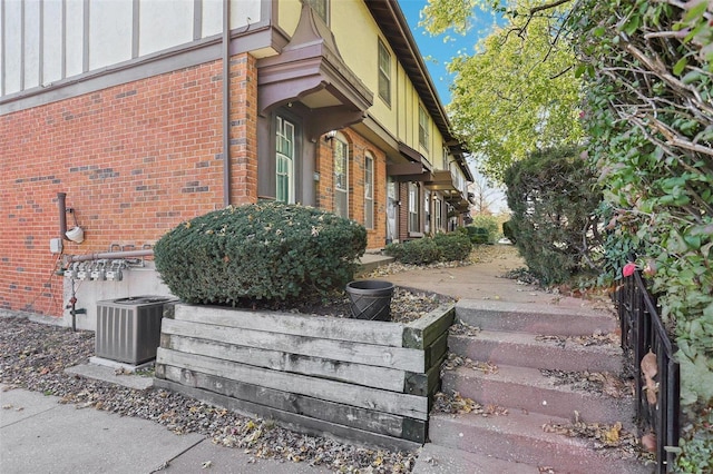 view of side of home featuring central air condition unit and brick siding