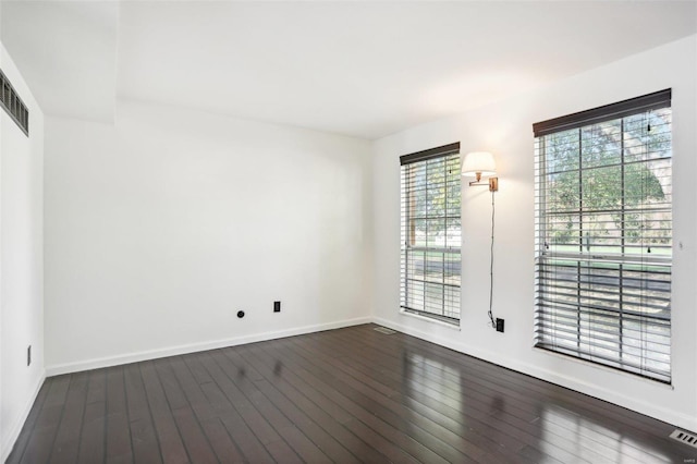 unfurnished room featuring dark wood-type flooring and baseboards