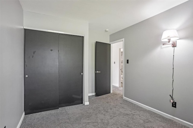 unfurnished bedroom with a closet, baseboards, and carpet