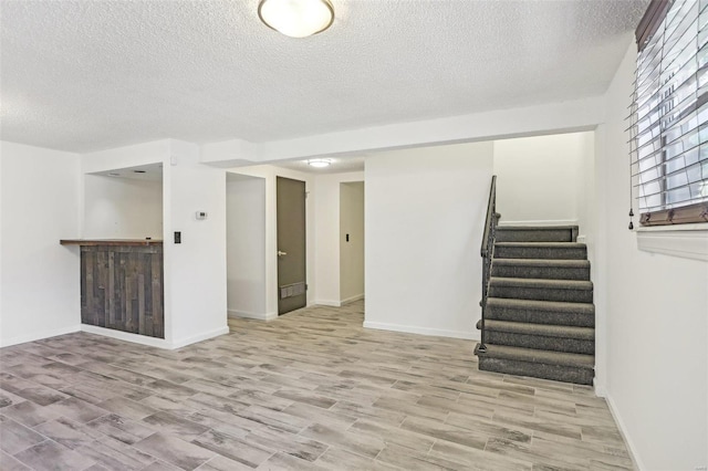 interior space featuring stairs, baseboards, and wood finished floors