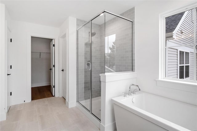 bathroom featuring plenty of natural light and shower with separate bathtub