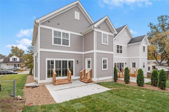 rear view of house with a lawn and a patio