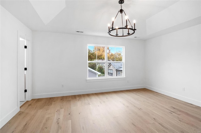 unfurnished dining area featuring a notable chandelier and light hardwood / wood-style floors