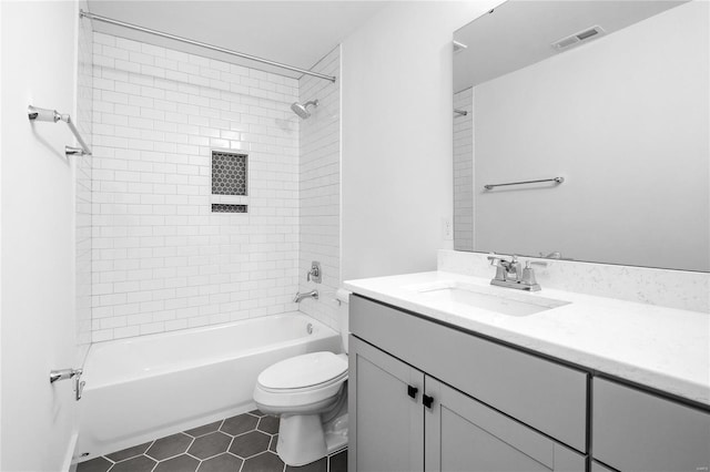 full bathroom featuring toilet, tiled shower / bath combo, vanity, and tile patterned floors