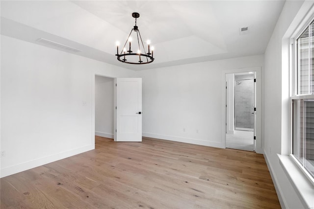 unfurnished room featuring light hardwood / wood-style floors and a chandelier