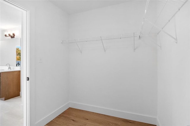 walk in closet featuring sink and light hardwood / wood-style floors