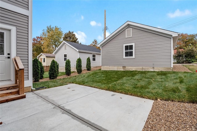 view of property exterior with a lawn and a patio area