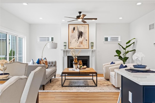 living room with ceiling fan and light hardwood / wood-style flooring