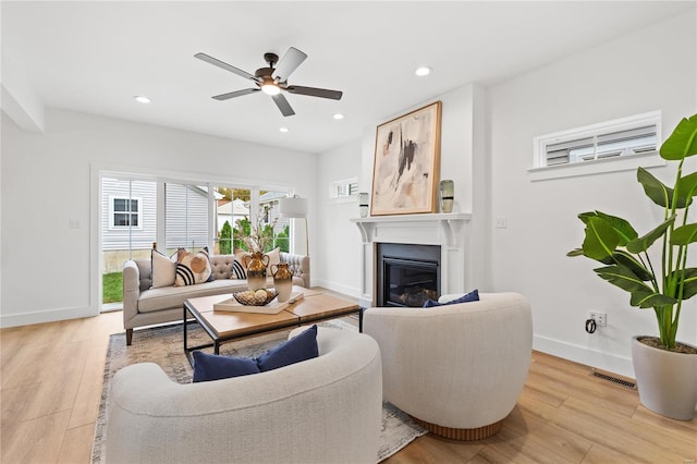 living room featuring ceiling fan and light hardwood / wood-style flooring