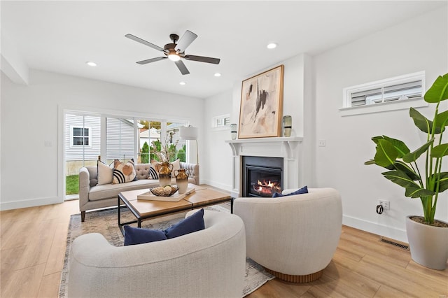 living room featuring ceiling fan and light hardwood / wood-style flooring