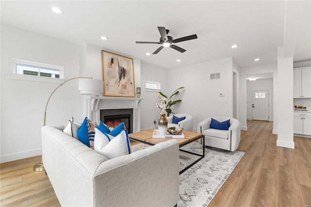 living room with ceiling fan and light wood-type flooring