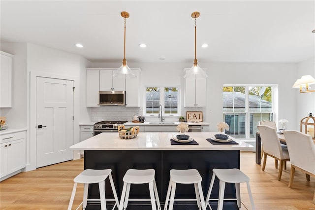 kitchen featuring appliances with stainless steel finishes, plenty of natural light, pendant lighting, and sink