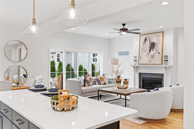 kitchen with gray cabinetry, ceiling fan, light wood-type flooring, and hanging light fixtures