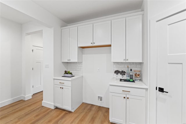 kitchen featuring light hardwood / wood-style flooring, white cabinetry, and tasteful backsplash