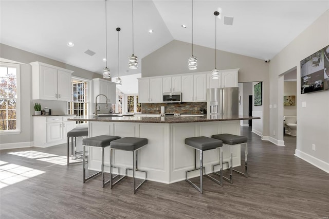 kitchen featuring a kitchen island with sink, white cabinetry, and stainless steel appliances