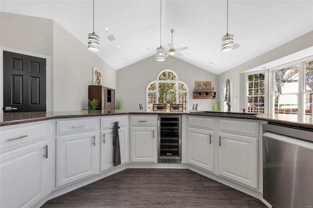 kitchen featuring a wealth of natural light, dishwasher, sink, wine cooler, and white cabinets