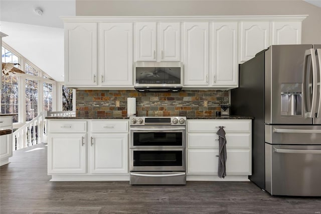 kitchen with dark stone countertops, white cabinetry, decorative backsplash, and appliances with stainless steel finishes