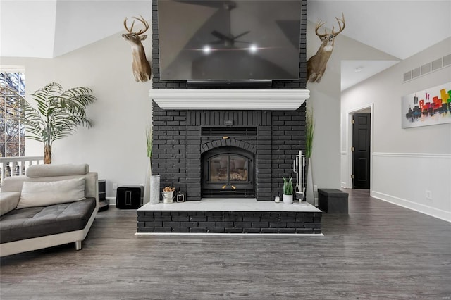 living room with a fireplace, dark hardwood / wood-style floors, and vaulted ceiling