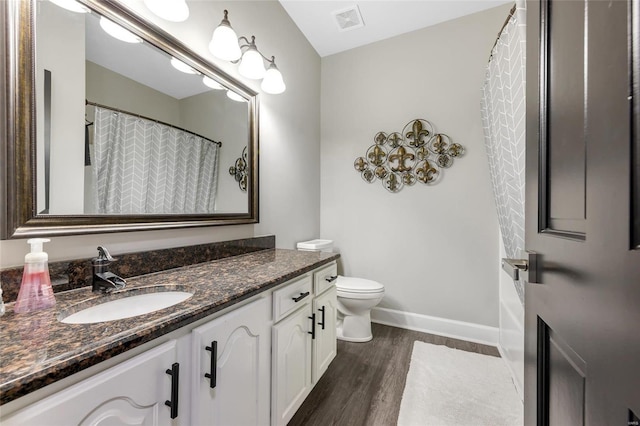 bathroom with hardwood / wood-style floors, vanity, and toilet