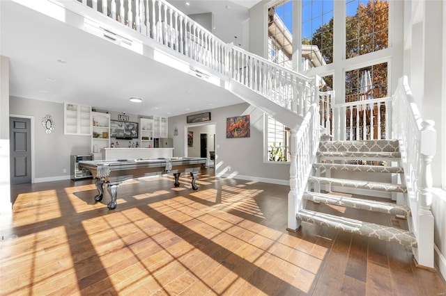 playroom featuring hardwood / wood-style floors, a towering ceiling, and pool table