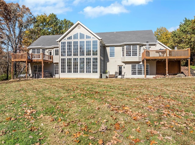 back of house featuring a lawn and a wooden deck