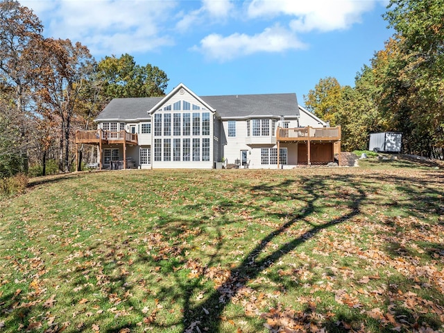 rear view of property with a storage shed, a yard, and a wooden deck