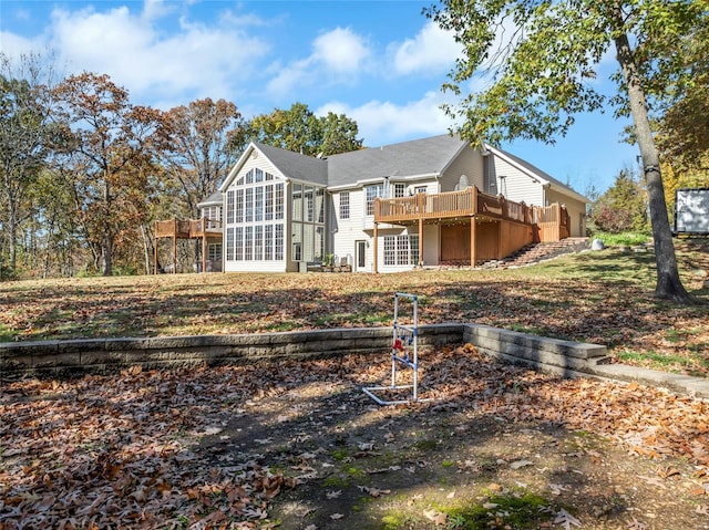 back of property featuring a deck and a sunroom