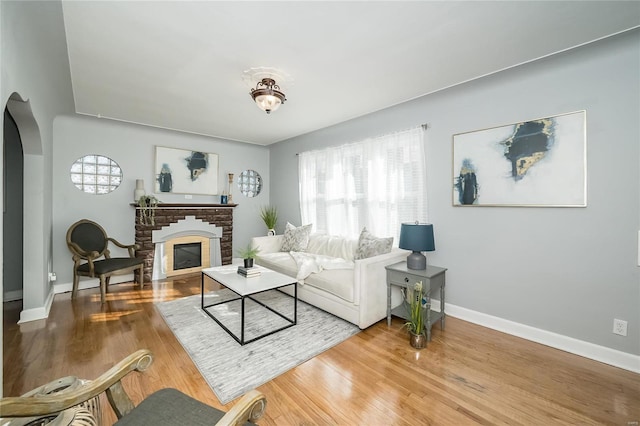 living room with hardwood / wood-style floors and a brick fireplace