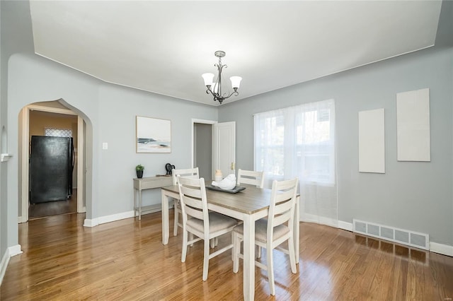 dining area with an inviting chandelier and hardwood / wood-style floors