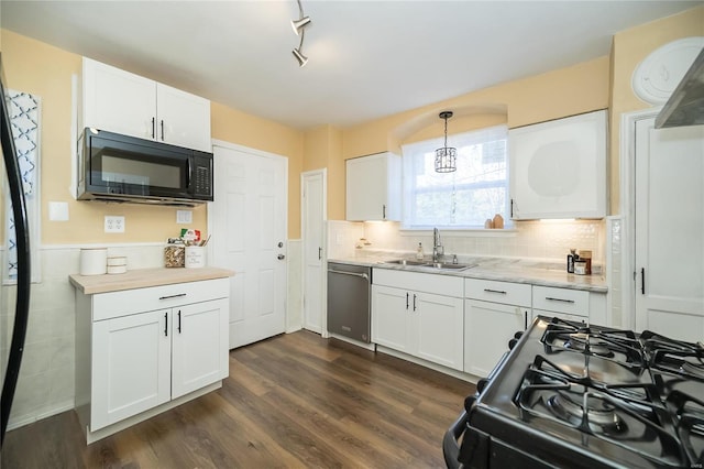 kitchen with stainless steel appliances, decorative light fixtures, sink, white cabinets, and dark wood-type flooring