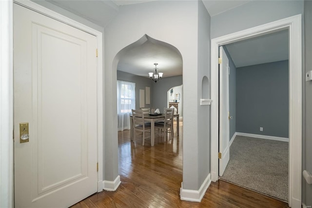 corridor featuring a notable chandelier and dark hardwood / wood-style floors