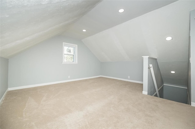 additional living space featuring lofted ceiling and carpet flooring