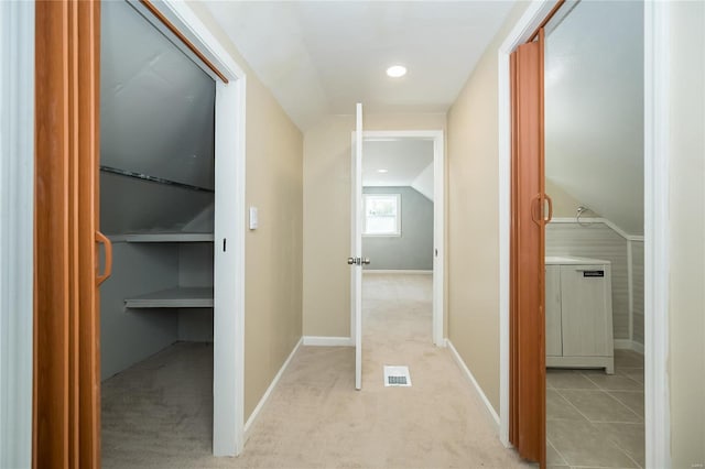 hall featuring light colored carpet and vaulted ceiling