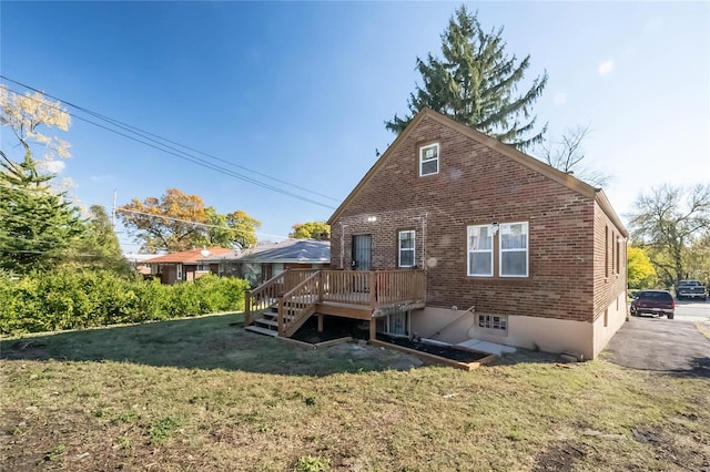 rear view of property with a yard and a deck